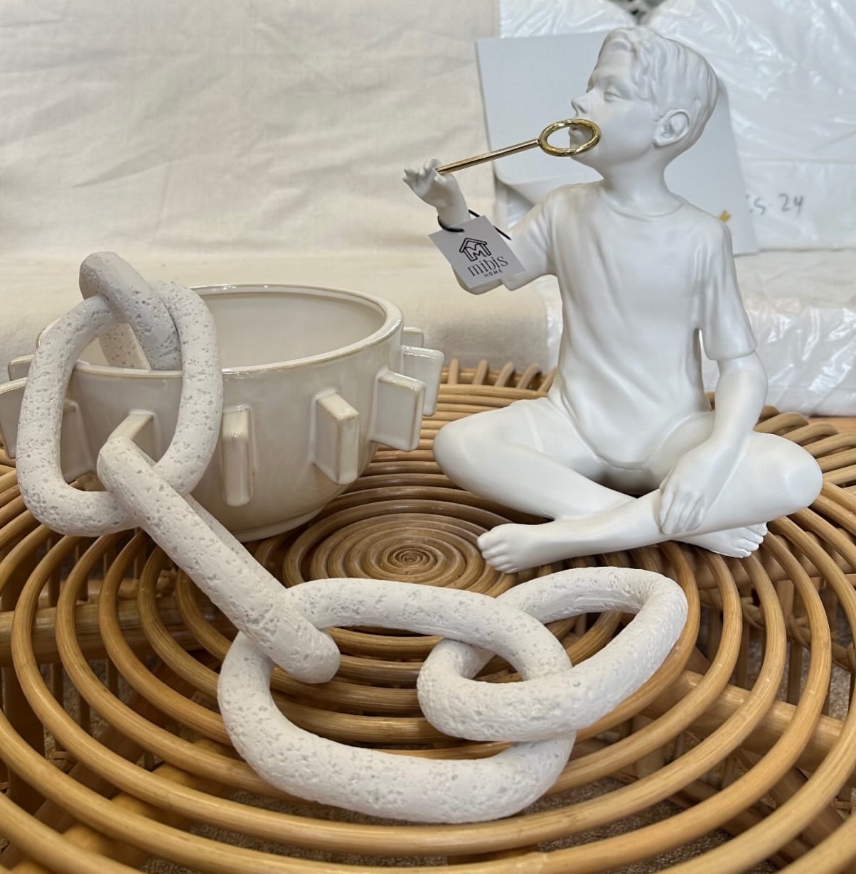 Escultura decorativa apoiada em bandeja com objetos